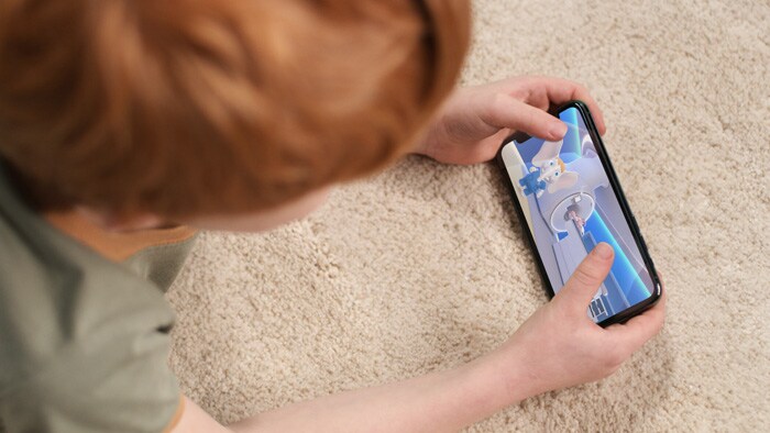 Child using pediatric coaching on a smart device to make preparing for an MR exam less stressful