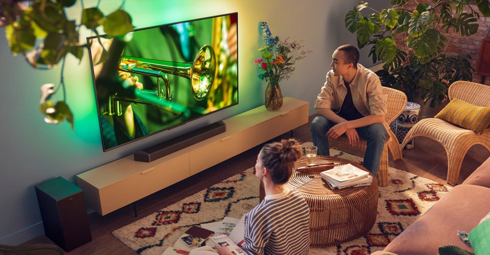 İnsanlar net soundbar sesine sahip Philips Ambilight TV'lerinin keyfini çıkarıyor