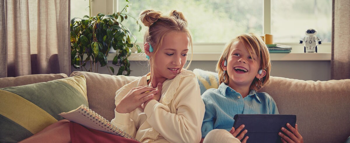 Philips açık kulak tasarımlı çocuk kulaklıklarıyla video izlemenin keyfini çıkaran çocuklar