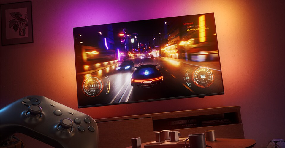 Loş ışıklı bir odada Philips Ambilight TV'de yarış video oyunu gösteriliyor